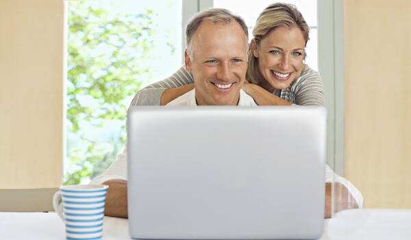 Ein Pärchen sucht am Laptop nach Reisen Ein Pärchen sucht am Laptop nach Reisen