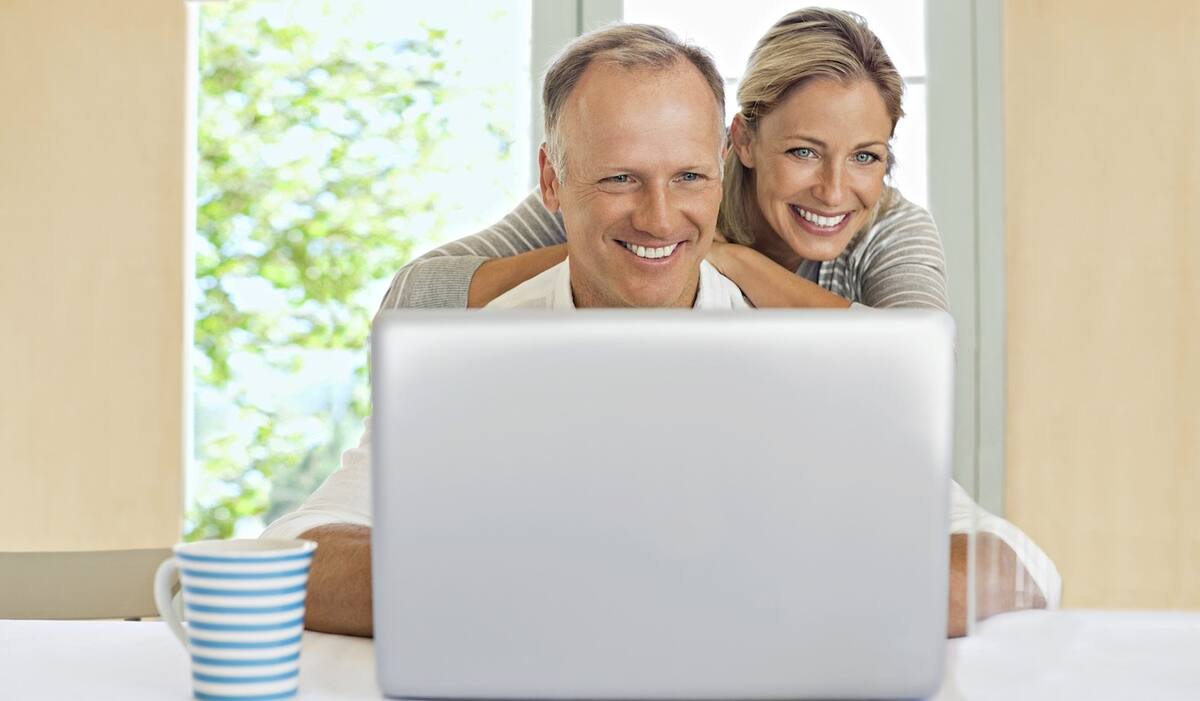 Ein Pärchen sucht am Laptop nach Reisen