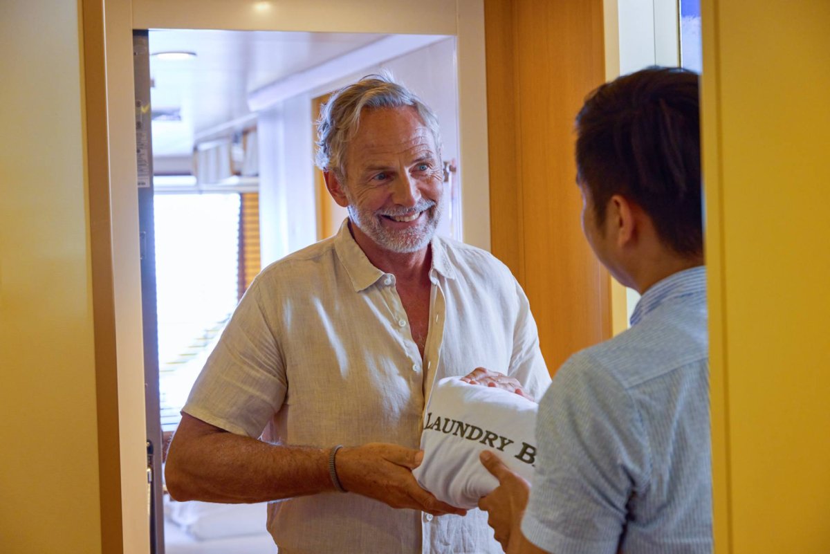 Service bei AIDA Mann übergibt Paket dem Wäscheservice auf AIDA