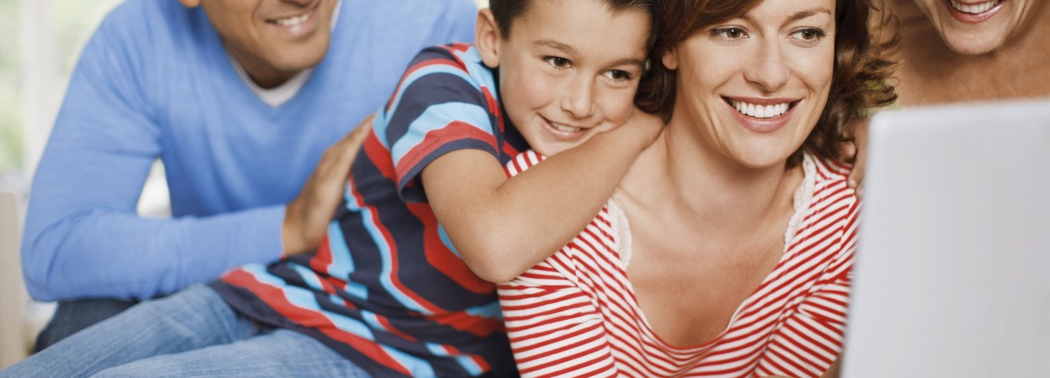 Familie plant vor einem Laptop ihre nächste Reise