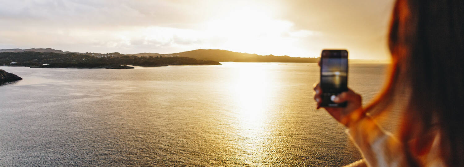 Frau fotografiert den Sonnenuntergang