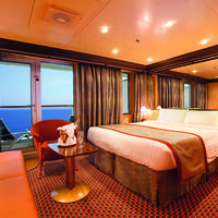 Bett und Sitzgelegenheiten mit Blick auf Balkon und Meer