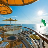 Blick vom Achterdeck auf das Meer und den Horizont, im Vordergrund Tische und Stühle vom Cafe