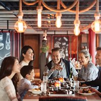 Foto: Erstklassiges Barbecue mit Burgern, Steaks und Ribs; Familie beim gemeinsamen Abendessen