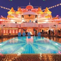 Erleuchtetes Sonnendeck mit Pool bei Nacht